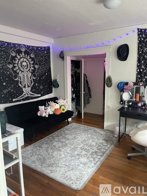 A room with a skeleton tapestry on the wall and a grey rug on the floor.