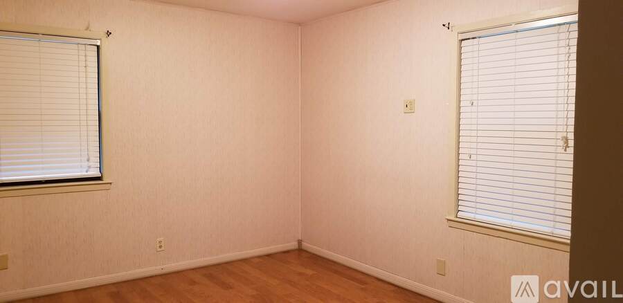 A room with a window and a wooden floor.