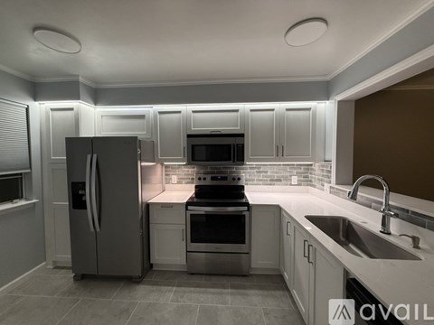 A modern kitchen with stainless steel appliances and white cabinets.