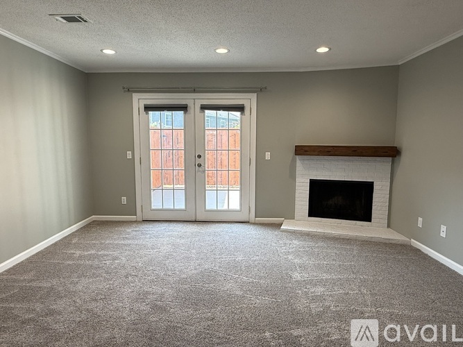 A spacious living room with a fireplace and large windows.