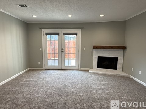 A spacious living room with a fireplace and large windows.