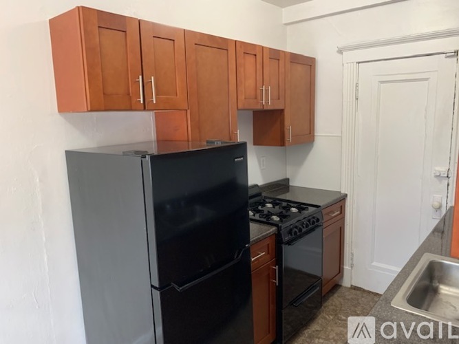 A kitchen with a black refrigerator and stove.