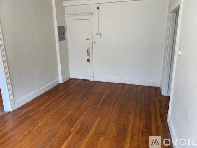A room with wooden flooring and a white door.