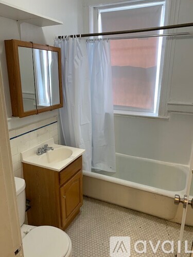A bathroom with a toilet, sink, and bathtub.