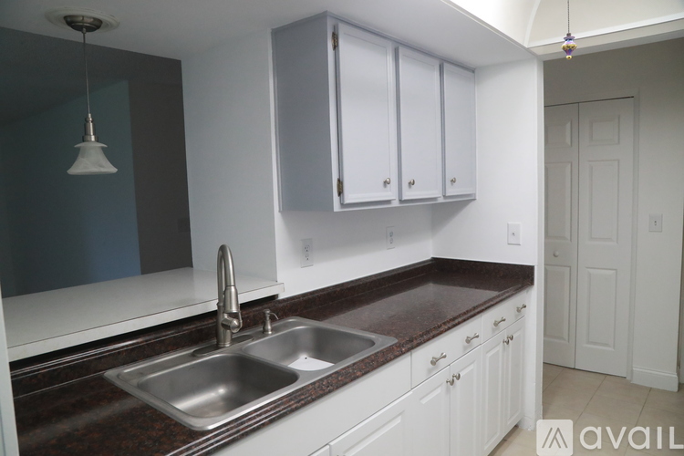 A kitchen with white cabinets and a brown countertop.