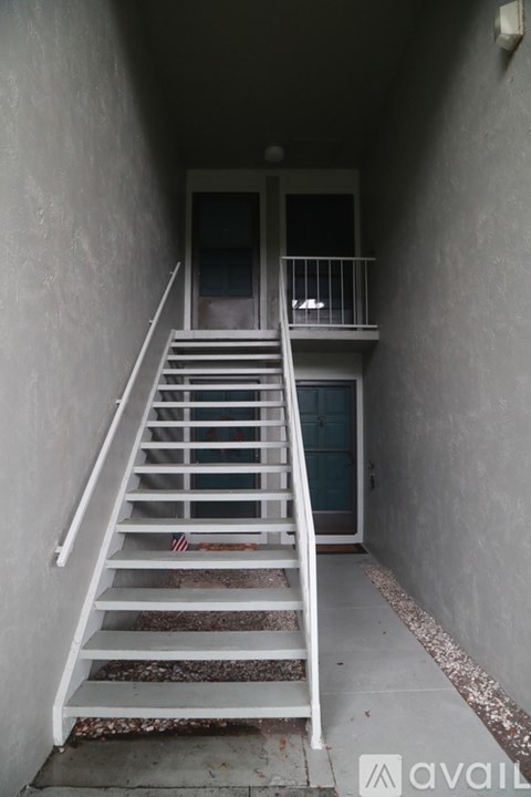 A staircase with a metal railing leads to a door.