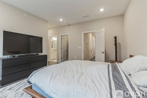 A bedroom with a large bed and a television.
