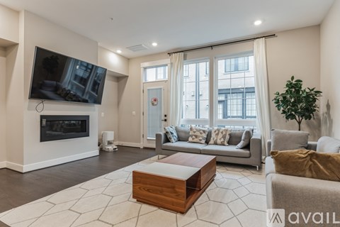 A living room with a fireplace and a television on the wall.