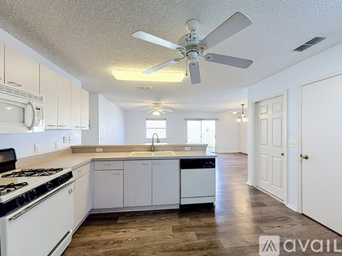 A kitchen with white cabinets and a black stove top.