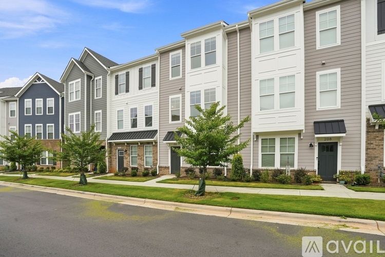 A row of modern townhouses with a clear blue sky above them.