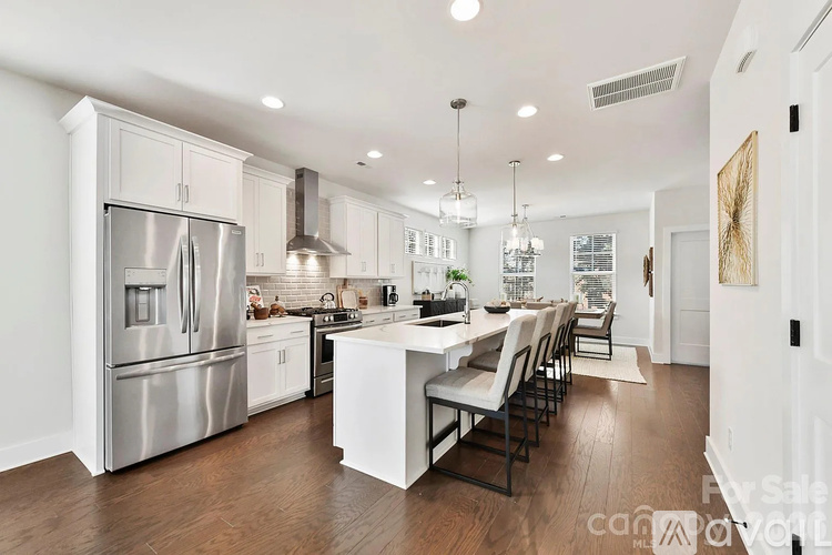 A modern kitchen with a large island and stainless steel appliances.