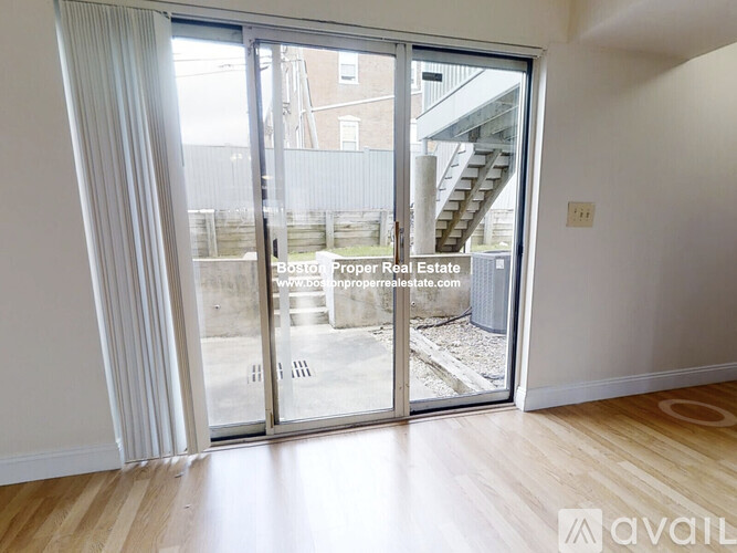 A room with a sliding glass door leading to a balcony.