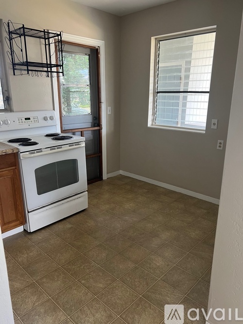 A kitchen with a white stove and a window.