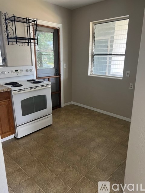A kitchen with a white stove and a window.