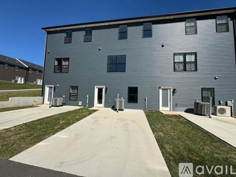 A grey building with a white walkway in front.