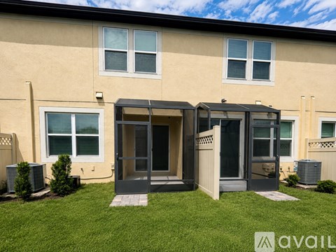 A beige apartment building with a black awning and a white door.
