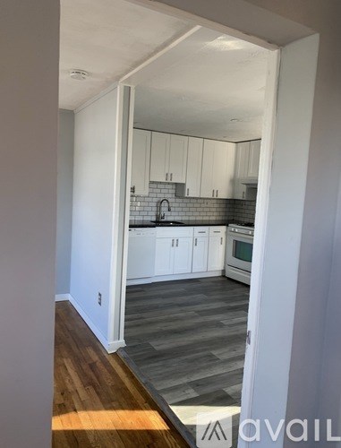 A kitchen with white cabinets and a black and white backsplash.