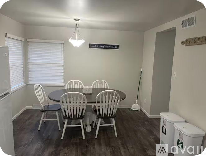A dining room with a round table and chairs.