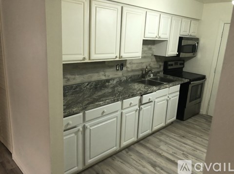 A kitchen with white cabinets and a black stove top oven.