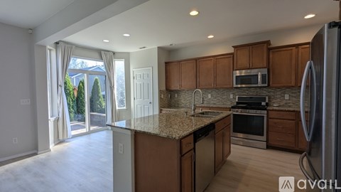 A kitchen with brown cabinets and a granite countertop.