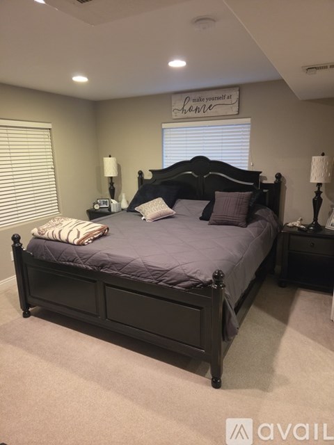 A bedroom with a large bed and a sign above it that says "make yourself at home".