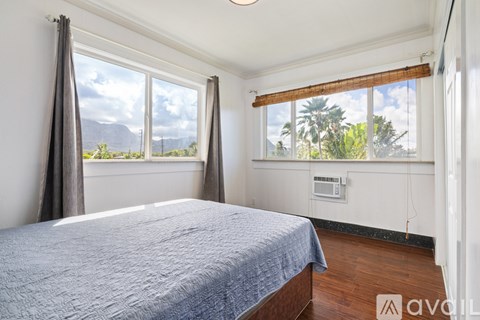 A bedroom with a large bed and a window overlooking a mountainous landscape.