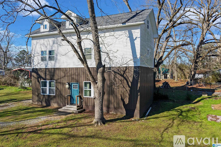 A house with a white and brown exterior and a blue door is for sale.
