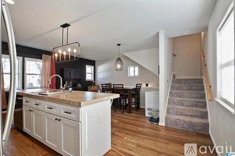 A kitchen with white cabinets and a wooden floor.