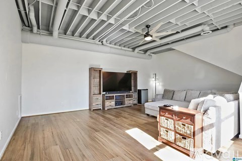 A living room with a white couch and a television.