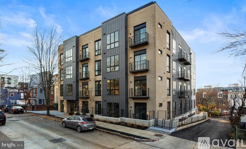 A modern apartment building with a car parked in front.