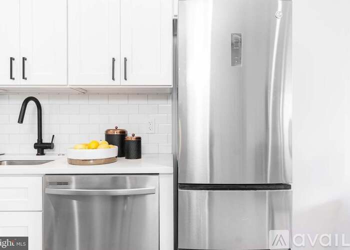 A modern kitchen with a stainless steel refrigerator and a dishwasher.