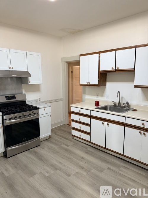 A kitchen with white cabinets and a stainless steel oven.