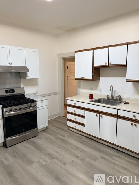 A kitchen with white cabinets and a stainless steel oven.