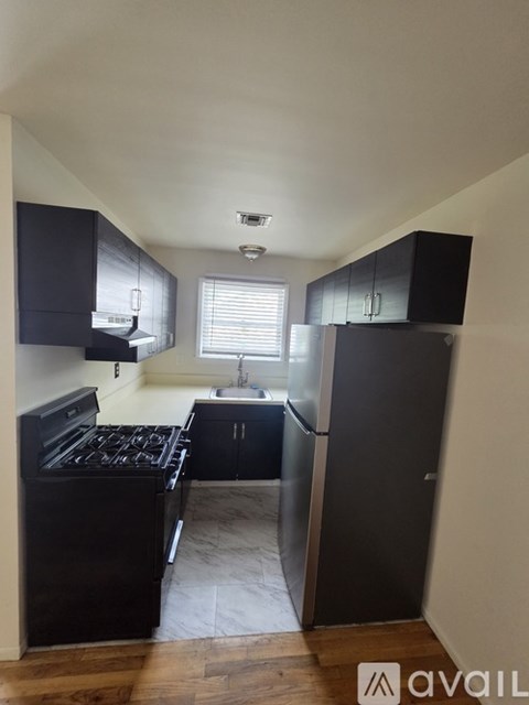 A kitchen with black cabinets and a stove top oven.