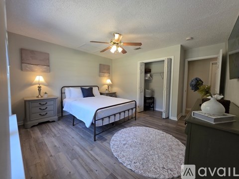 A bedroom with a bed, dresser, and ceiling fan.
