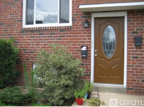 A brown door with a glass window is on a brick house.