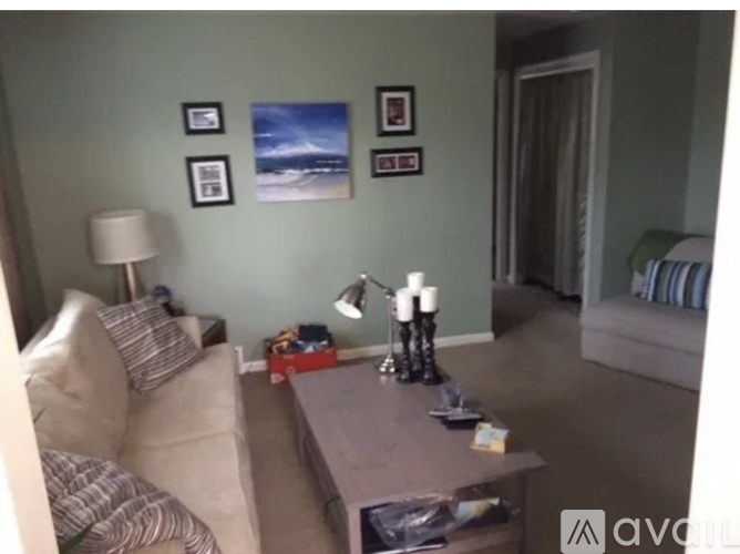 A living room with a couch, coffee table, and pictures on the wall.