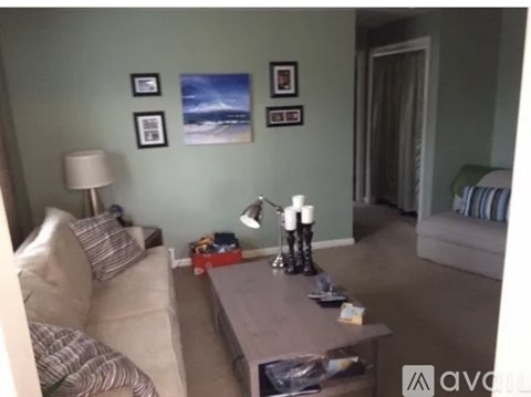 A living room with a couch, coffee table, and pictures on the wall.