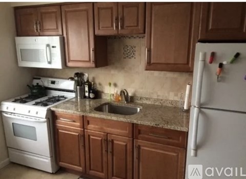 A kitchen with brown cabinets and a white refrigerator.
