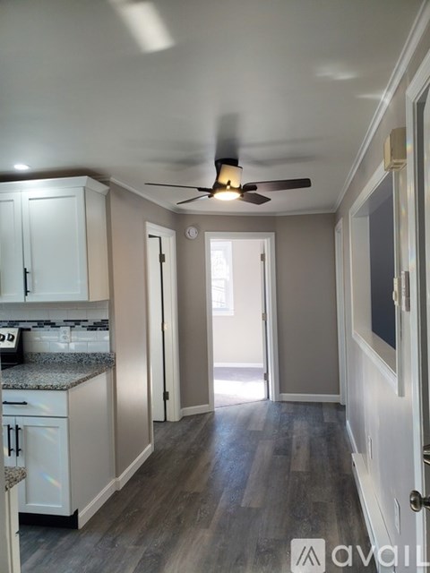 A well-lit kitchen with a ceiling fan and a view of the backyard.