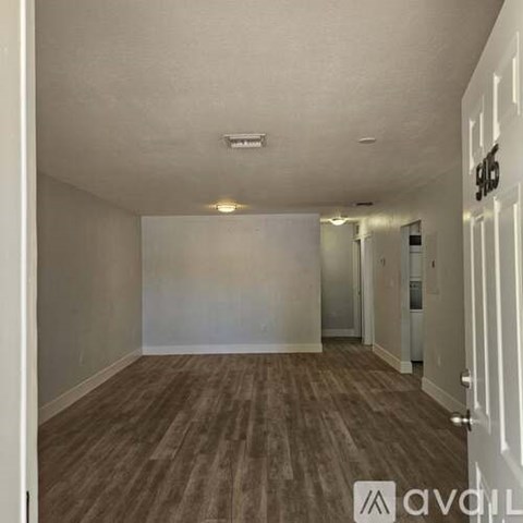 A room with wooden flooring and white walls.