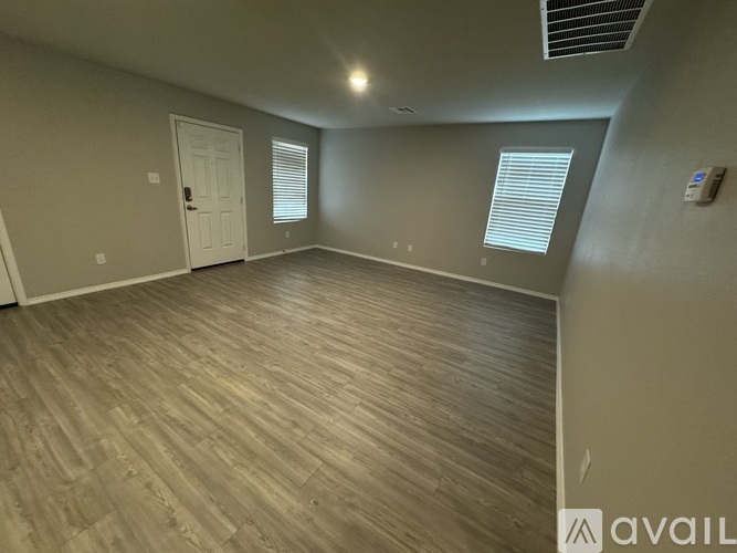 A room with wooden flooring and a white door.
