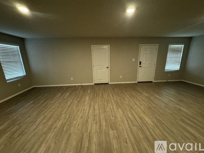 A room with wooden flooring and two white doors.