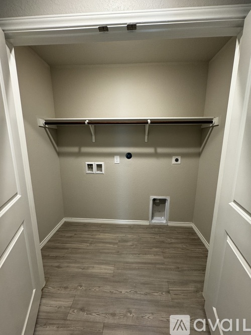 A small, empty room with a shelf and a vent.