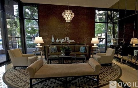 A living room with a sofa, chairs, and a chandelier.