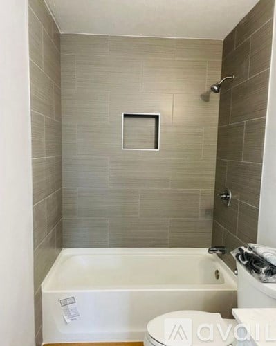 A bathroom with a white tub and toilet.
