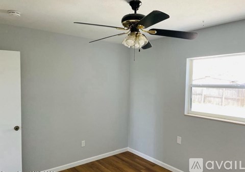 A room with a ceiling fan and a window.