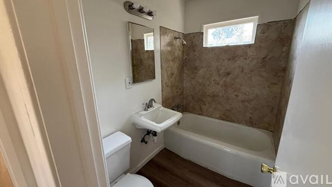 A bathroom with a tub, toilet, and sink.