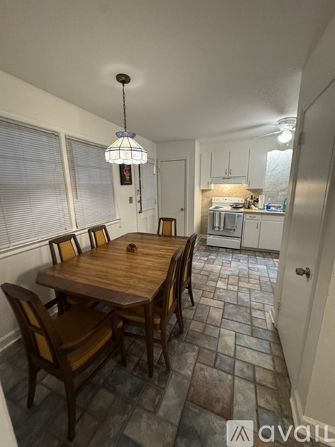 A dining room with a wooden table and chairs.