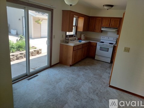 A kitchen with a white oven and wooden cabinets.